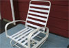 Metal glider with white vinyl strap seat.